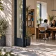 Espacio comercial contemporáneo visto desde el exterior, con personas conversando en el interior.
